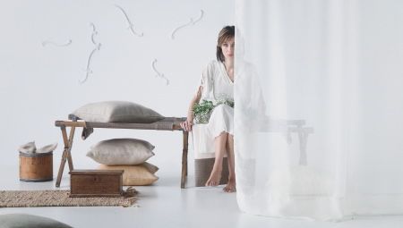 Femme assise derrière un rideau en lin blanc